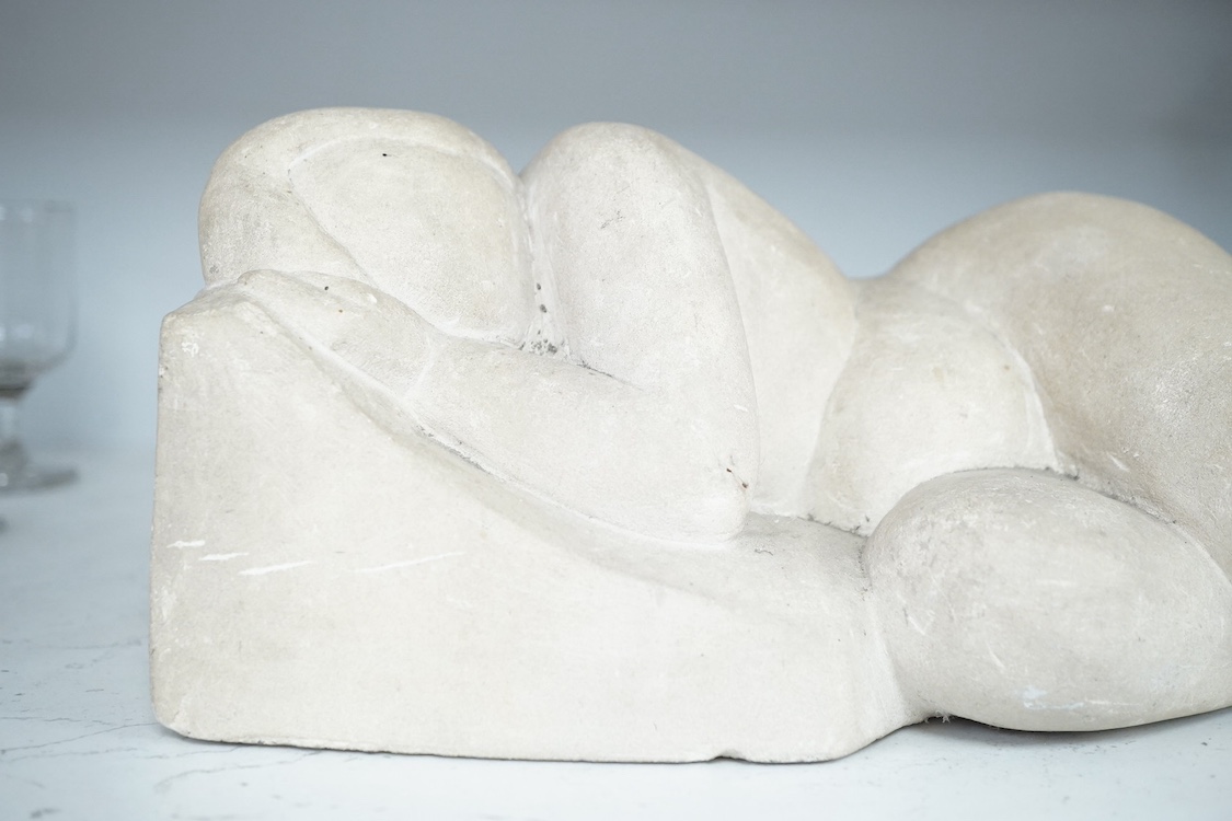 A stone carving of a sleeping nude woman, monogrammed MH, 37cm wide. Condition - fair
